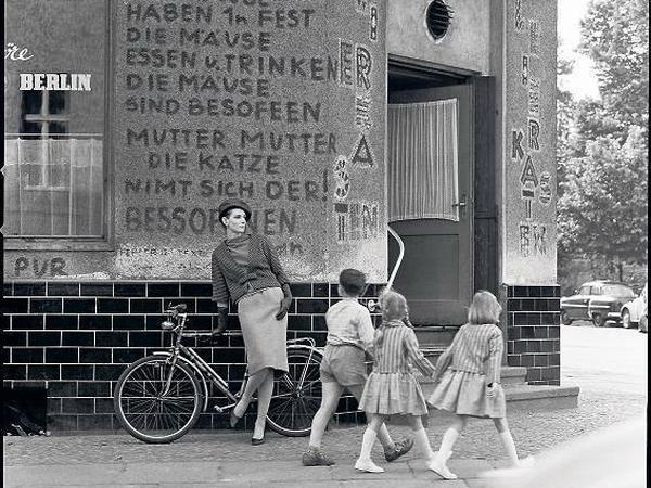 „Das war 1962 mein erstes Foto in Kreuzberg“, erinnert sich F. C. Gundlach. „Wir sind durch die Stadt gefahren und haben die Wand mit dem Gedicht gefunden, die Kneipe hieß Leierkasten. Das Model Trudy war super, die hat später einen Freund von mir geheiratet. Die Kinder gingen zufällig durchs Bild, da musste ich schnell reagieren.“ 