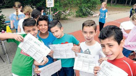 Beim Sportfest der Müggelschlösschen-Grundschule in Köpenick präsentieren Milan (links) und seine Kumpels aus der Willkommensklasse ihre Urkunden.