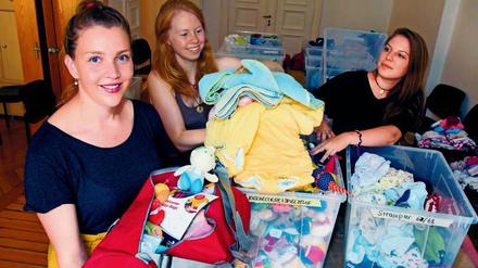 Projektleiterin Amelie Schwermer, Pia Meier und Mia Linthe (von links) beim packen der Babybags.