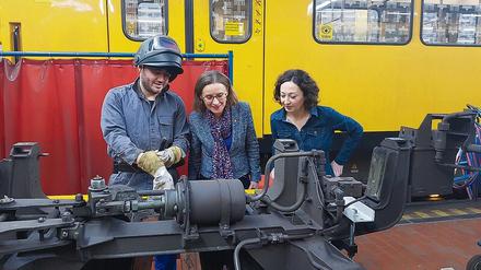 Die BVG-Chefin Sigrid Nikutta (Mitte) hier mit Aufsichtsratschefin Ramona Pop (rechts) und einem Mitarbeiter in der Werkstatt. 