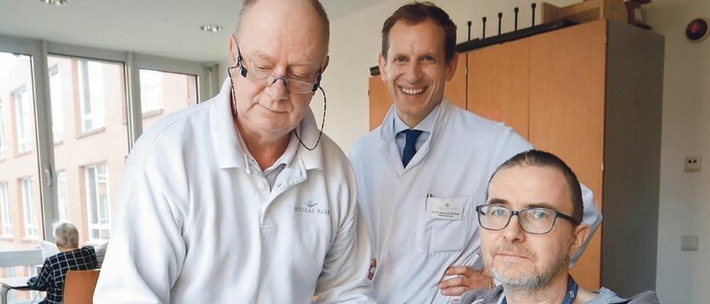 Muskeln aufbauen. Ergotherapeut Jürgen Dahm, Chefarzt Martin Ebinger und Patient Nils Pfeiffer in Aktion. 