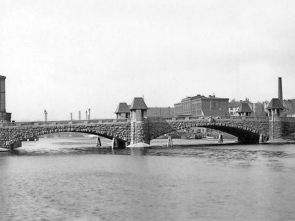 So sah die Brommybrücke im Jahr 1910 aus. Sie führte von Kreuzberg in Höhe der Eisenbahnstraße über die Spree nach Friedrichshain zur Mühlenstraße. Zum Ende des Zweiten Weltkriegs wurde die Brücke gesprengt, um die vom Osten anrückende Rote Armee aufzuhalten.