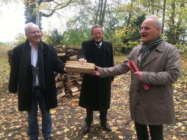 Ein Stück Holz, sie alle zu einen. Hoteldirektor Burkhard Scholz (l-r), der Vorsitzende des Bau-Ausschusses, Wieland Niekisch (CDU) und der Baubeigeordnete Bernd Rubelt.