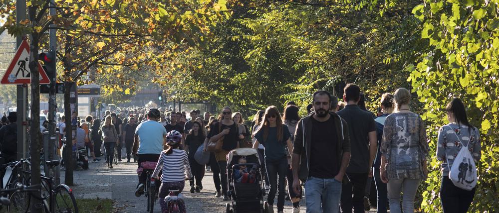 Besucher und Einheimische ziehen an einem warmen und sonnigen Herbstsonntag in den Berliner Mauerpark.