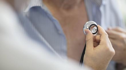 Ein Arzt horcht einen Patienten mit einem Stethoskop ab (Symbolbild).
