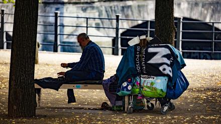 Ein Obdachloser sitzt auf einer Bank im Lustgarten auf der Museumsinsel.