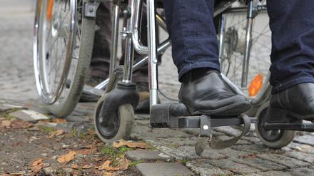 Alltag: Ein Rollstuhlfahrer bleibt mit seinem Rad im Kopfsteinpflaster hängen