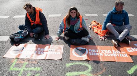 Klimademonstranten der so genannten Letzten Generation kleben auf der Fahrbahn einer Hauptstrasse am Ernst-Reuter-Platz in Berlin-Charlottenburg. 