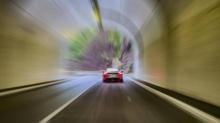 Autofahrer in Sportwagen fährt mit überhöhter Geschwindigkeit durch Tunnel.
