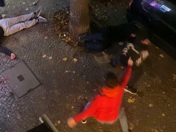 Attacke auf den Spätkauf in Neukölln. Zwei Männer (r.) flüchten, am Baum liegt ein Opfer des Angriffs 
