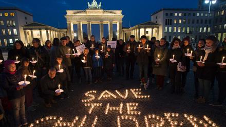 "Save the children" steht mit Kerzen gestaltet auf dem Boden vor dem Brandenburger Tor. 