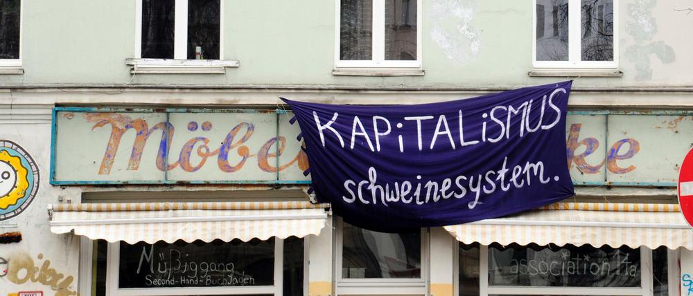 "Kapitalismus Schweinesystem" hängt an einem Haus in Oranienstraße in Berlin-Kreuzberg. 