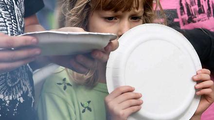 Sommerfest beim Kinderhilfswerk Arche: Ein Mädchen wartet auf ein Grillwürstchen. In Berlin ist fast jedes zweite Kind arm.