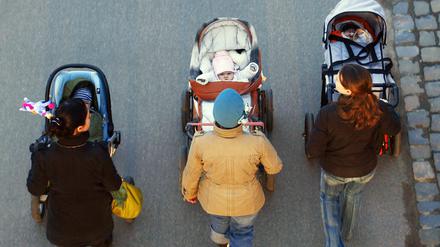 Drei junge Mütter schieben ihre Babys im Kinderwagen bei einem gemeinsamen Spaziergang. (Symbolbild)
