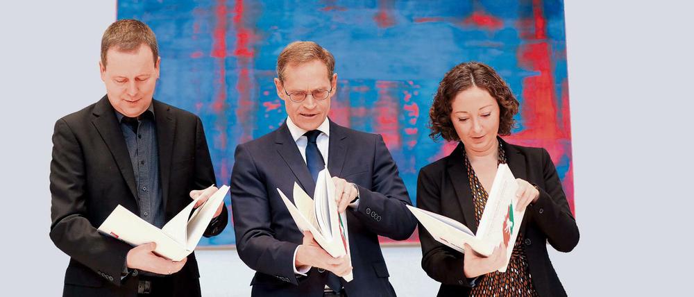 Klaus Lederer (l-r), Michael Müller und Ramona Pop, schauen nach der Unterzeichnung in den Koalitionsvertrag.