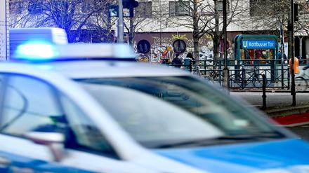 Polizeiwagen mit Blaulicht am Kottbusser Tor, im Hintergrund ein U-Bahn-Eingang.