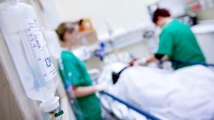 Medizinisches Personal versorgt in einem Krankenhaus einen Patienten (Symbolbild).