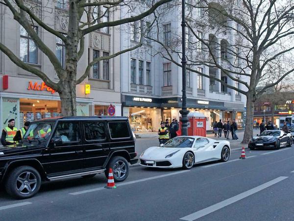 Ein Mercedes-Geländewagen, ein Ferrari und eine Corvette bei der Kontrolle auf dem Ku'damm nahe dem Lehniner Platz.