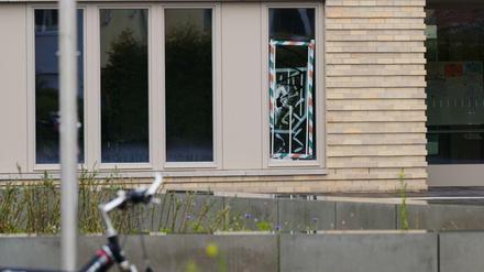 Eine kaputte Scheibe eines Außenfensters ist in der Fuchsberg Grundschule abgeklebt. Unbekannte haben ein Kunst-Vogelnest aus Gold aus der Schule in Berlin-Biesdorf gestohlen.