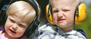 Kinder mit Lärmschutz auf den Ohren.