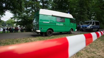 Polizeiwagen stehen am 13.06.2015 in Berlin im Treptower Park. Dort hatten am frühen Morgen Spaziergänger eine Leiche gefunden. 
