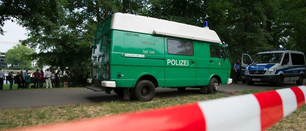 Polizeiwagen stehen am 13.06.2015 in Berlin im Treptower Park. Dort hatten Spaziergänger eine Leiche gefunden. Die Mordkommission ermittelt. 