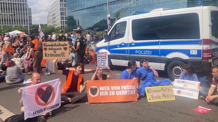 Aktivisten der Letzten Generation blockieren die Zufahrt vom Demokratiefest.