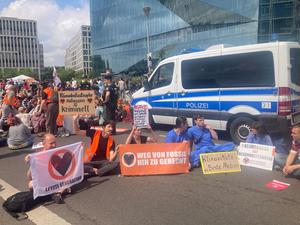 Aktivisten der Letzten Generation blockieren die Zufahrt vom Demokratiefest.