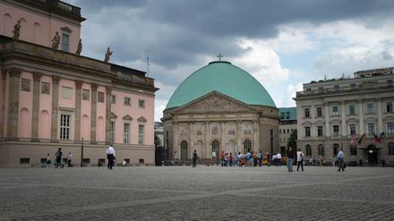 Die St. Hedwigs-Kathedrale in Berlin-Mitte. und der Bebelplatz unter drohenden Wolken.
