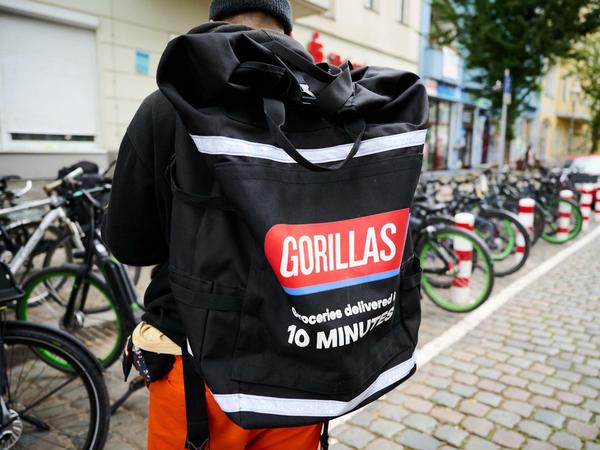 Ein Beschäftigter des Lieferdienstes Gorillas trägt einen Rucksack und steht vor den Fahrrädern. Auch diese Firma beansprucht öffentlichen Raum - zum Be- und Endladen der Räder.