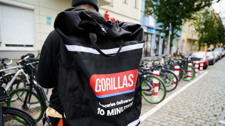 Ein Beschäftigter des Lieferdienstes Gorillas trägt einen Rucksack und steht vor den Fahrrädern. Die Fahrer demonstrieren seit Wochen gegen die Arbeitsbedingungen bei dem jungen Start-Up.