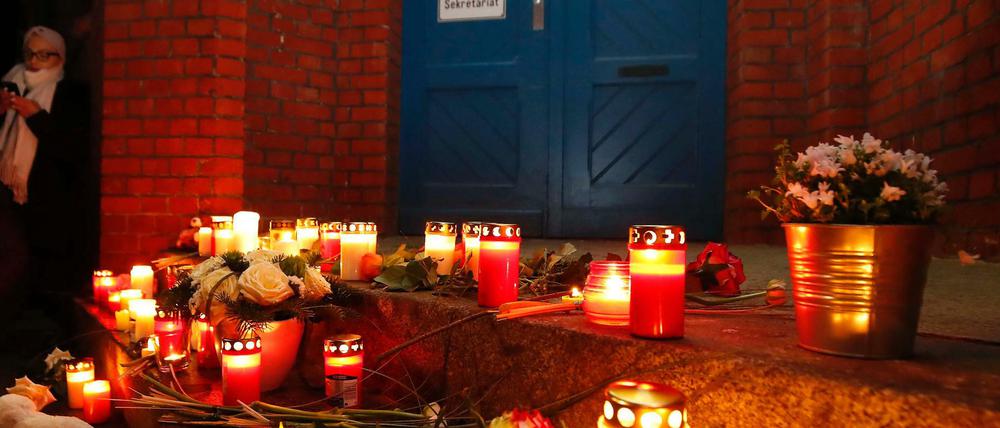 Kerzen brennen vor der Grundschule in Berlin-Reinickendorf, an der sich am Samstag 150 Menschen zur Mahnwache trafen. 