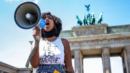 Eine Schwarze Frau demonstriert im Frühjahr 2020 vor dem Brandenburger Tor anlässlich der Tötung von George Floyd. 