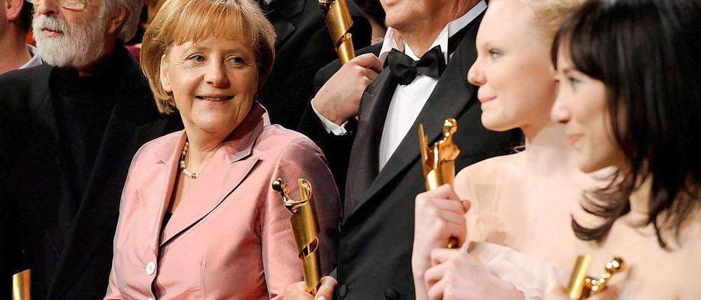 Regisseur Michael Haneke (l.), Bundeskanzlerin Angela Merkel, Filmproduzent Bernd Eichinger und die Schauspielerinnen Maria Victoria Dragus und Sibel Kekilli bei der Verleihung des Deutschen Filmpreises.