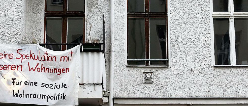 Ein Transparent gegen Wohnungsspekulationen hängt an einer Fassade eines Mietshauses im Berliner Bezirk Friedrichshain.