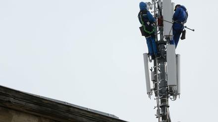 In luftiger Höhe werden Arbeiten an einem Mobilfunkmast in Berlin Kreuzberg vorgenommen.