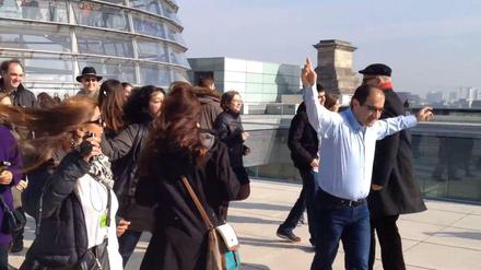 Er ist "happy": Özcan Mutlu und seine Besucher auf dem Dach des Bundestags.