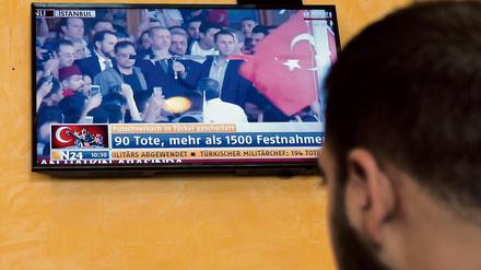 Ein türkischer Imbiss-Verkäufer schaut in Berlin im TV-Berichte aus der Türkei über den Putsch-Versuch. 