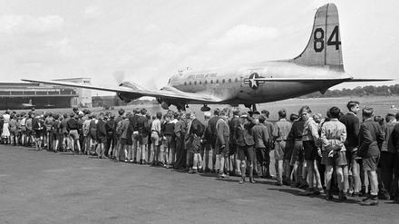 Kinder stehen 1949 auf dem Flughafen Berlin-Tempelhof und sehen der Landung eines US-amerikanischen Transportflugzeuges zu. 