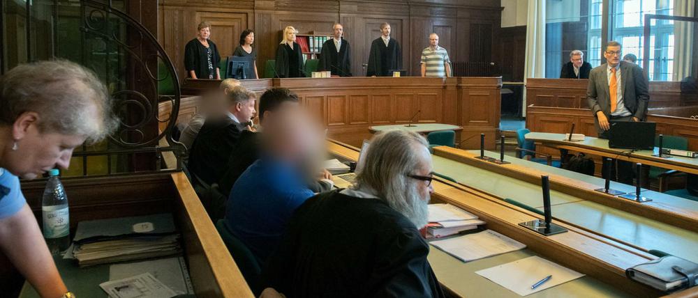 14. August 2018: Die Angeklagten sitzen in einem Gerichtssaal. 