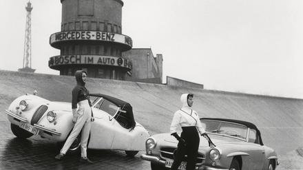 Models mit Mercedes-Sportwagen in der Steilkurve der Avus in den Fünfzigerjahren. Im HIntergrund Motel und Funkturm.