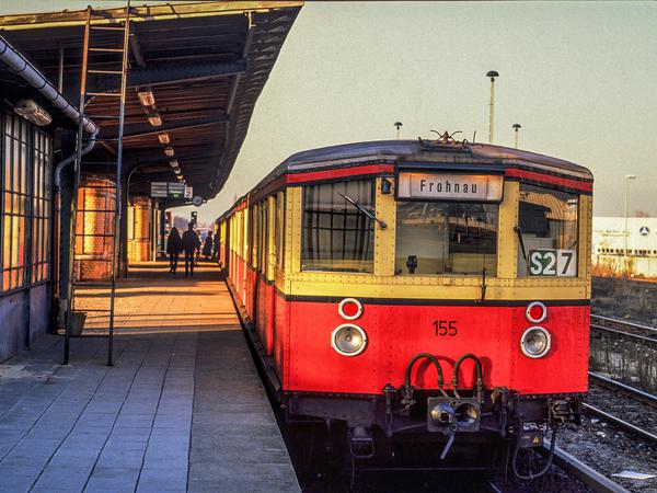 An der gleichen Stelle wie der Güterzug steht am 18.11.1989 in Marienfelde eine S-Bahn nach Frohnau am Bahnsteig.
