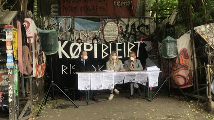 Bewohner:innen der Köpi-Wagenburg und der Anwalt Moritz Heusinger (1.v.l.) bei einer Pressekonferenz vor dem Gelände in Mitte.