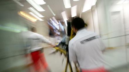 Rettungsassistenten liefern eine Notfallpatientin in ein Krankenhaus.