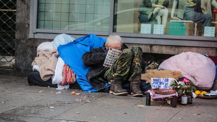 Ein Obdachloser bittet auf dem Hermannplatz in Berlin Neukölln um Spenden.
