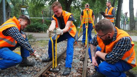 Mit einer Spezial-Ratsche ziehen die BVG-Gleisbauer-Azubis lockere Muttern der Parkeisenbahn-Gleise in der Wuhlheide fest 