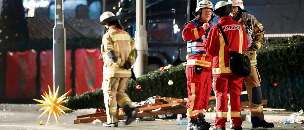 Eine Stadt unter Schock. Rettungskräfte am Breitscheidplatz, dahinter ein umgeknickter Christbaum mit Weihnachtsstern.