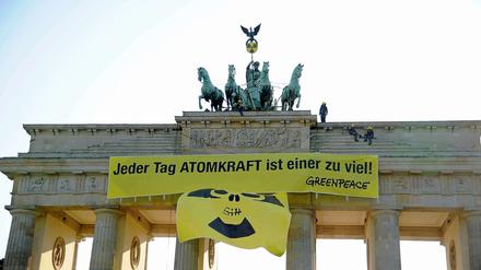 Mit Gelb-Schwarz gegen Schwarz-Gelb: Greenpeace demonstriert am Brandenburger Tor für einen raschen Atomausstieg. Die Bundesregierung einigte sich in der Nacht zu Montag auf einen Ausstieg bis spätestens 2022.