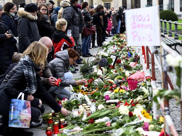 Hunderte von Blumensträußen liegen bereits an der Absperrung vor der Französischen Botschaft am Brandenburger Tor.