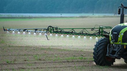 Ein Landwirt fährt in Brandenburg mit einer Pestizid- und Düngerspritze über ein Feld. 